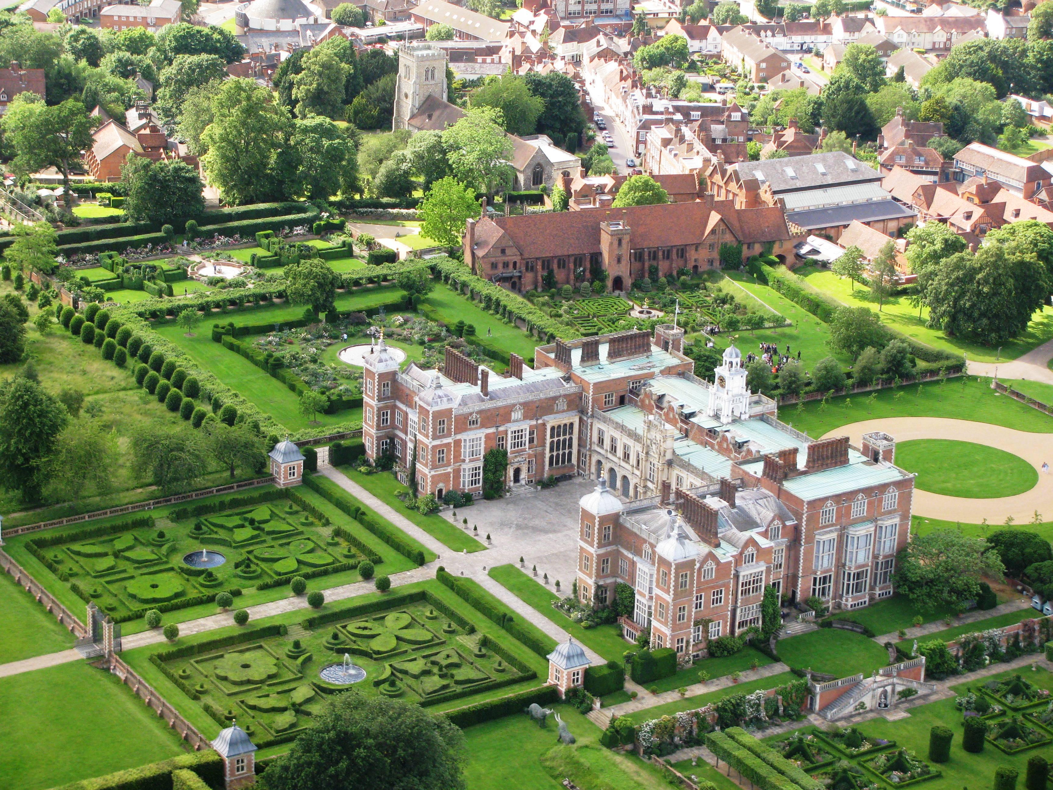 Image of Hatfield House surrounded by green fields and bushes