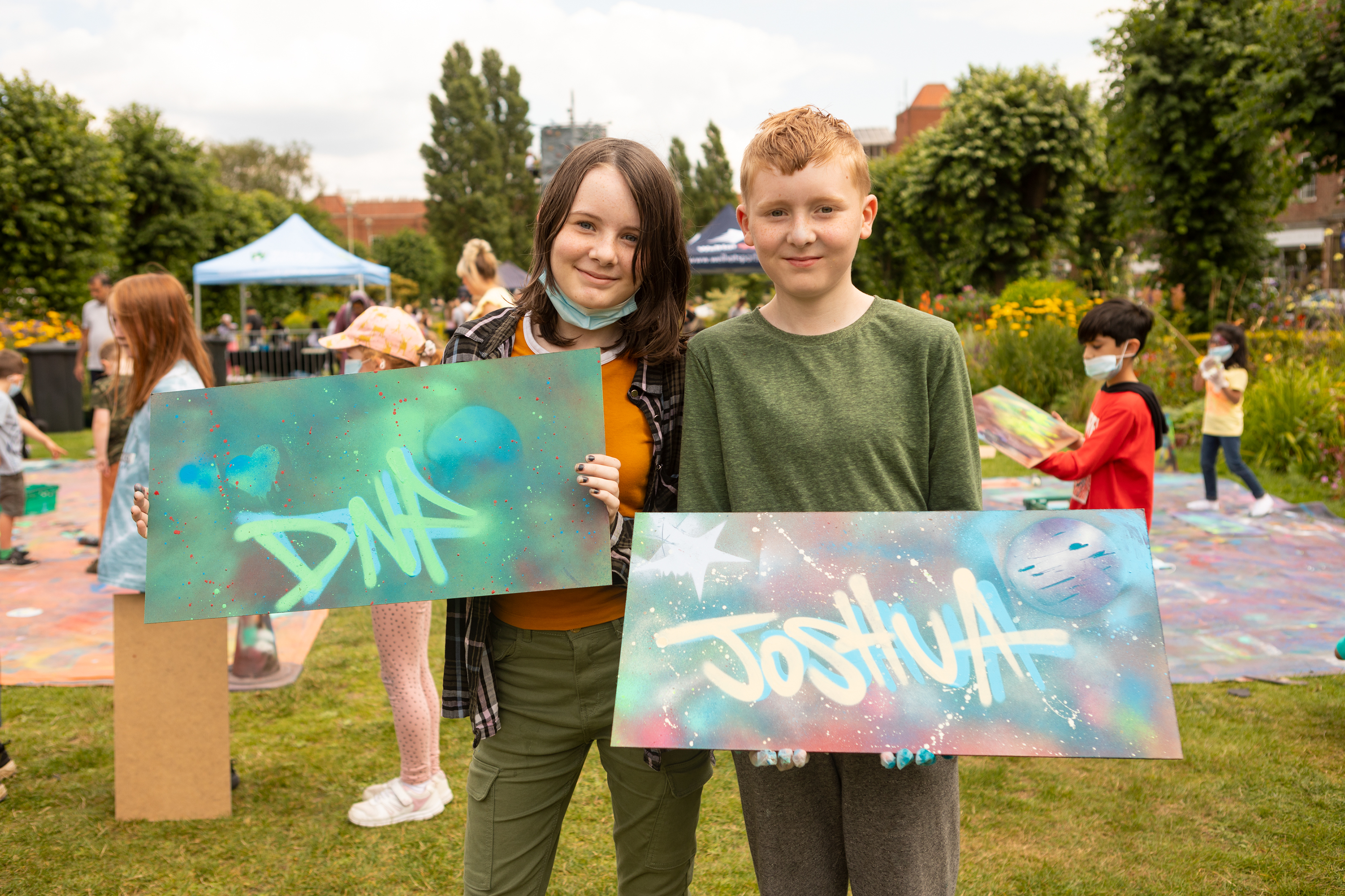 two teenagers holding their graffiti art