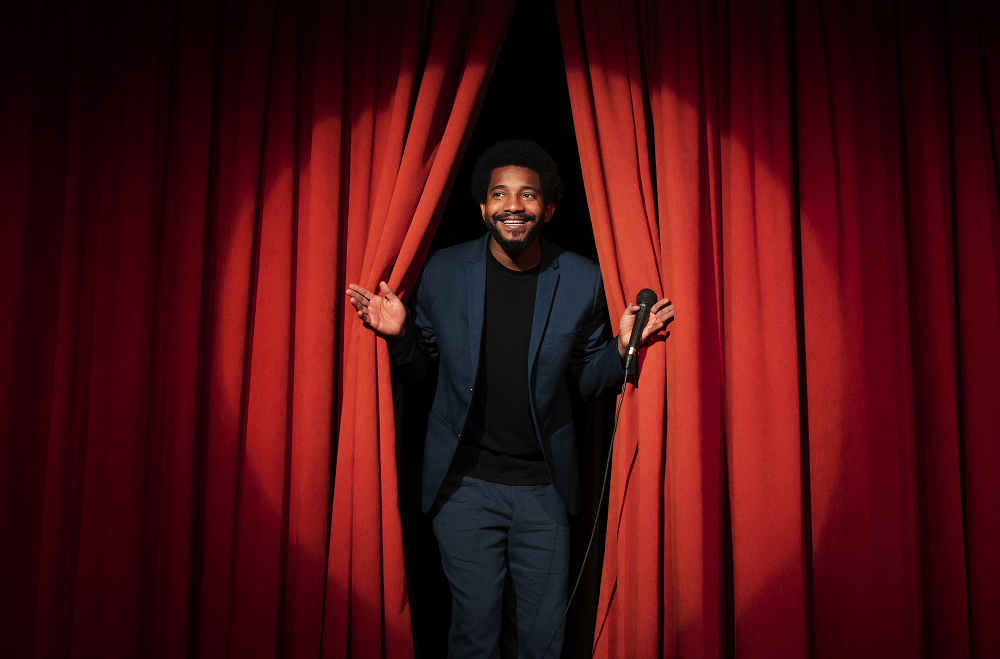 Comedian infront of red curtains