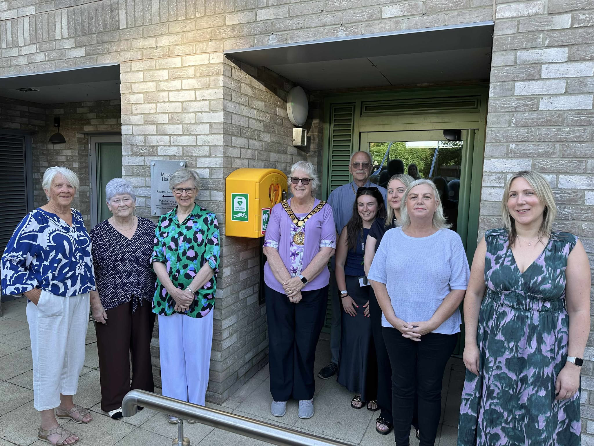 People gathered in front of the new defibrillator