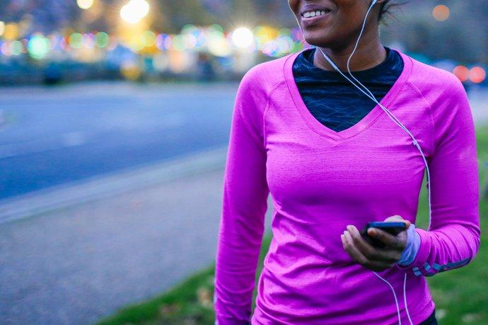 Woman in sports top with earphones in.