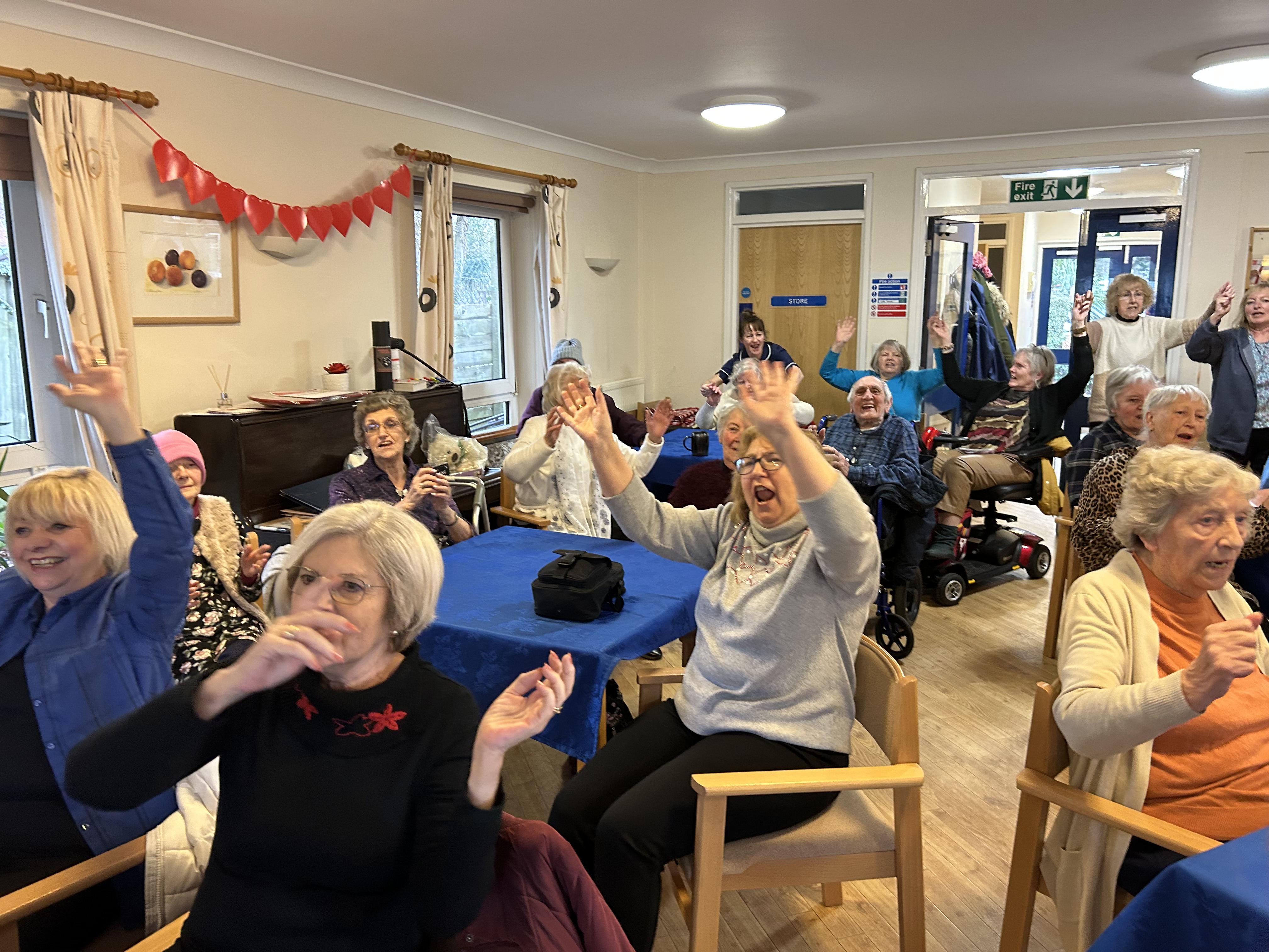 Group of older people singing/dancing to music.