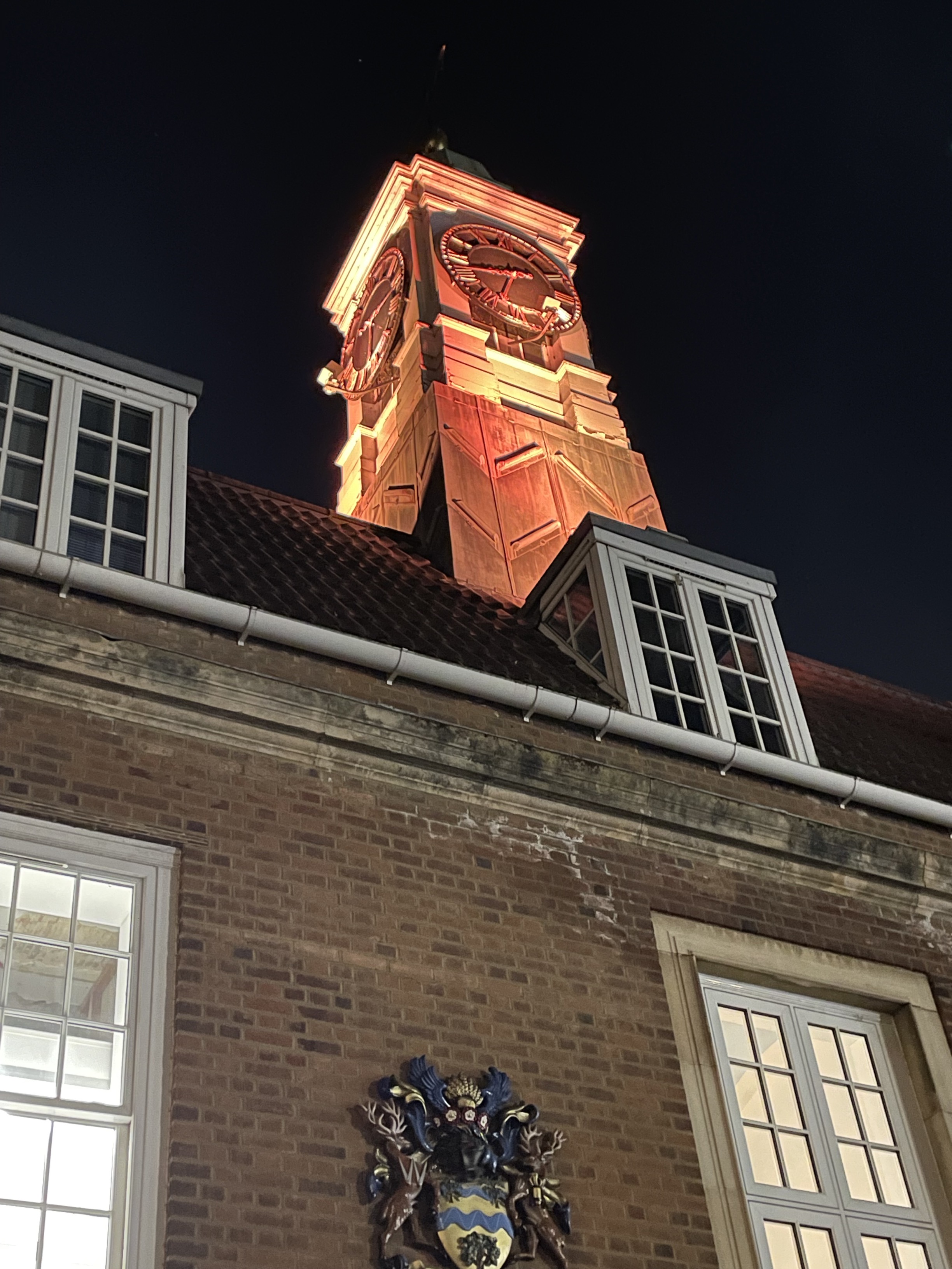Clock tower illuminating orange
