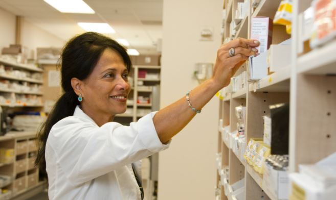 Pharmacist getting medication from shelf
