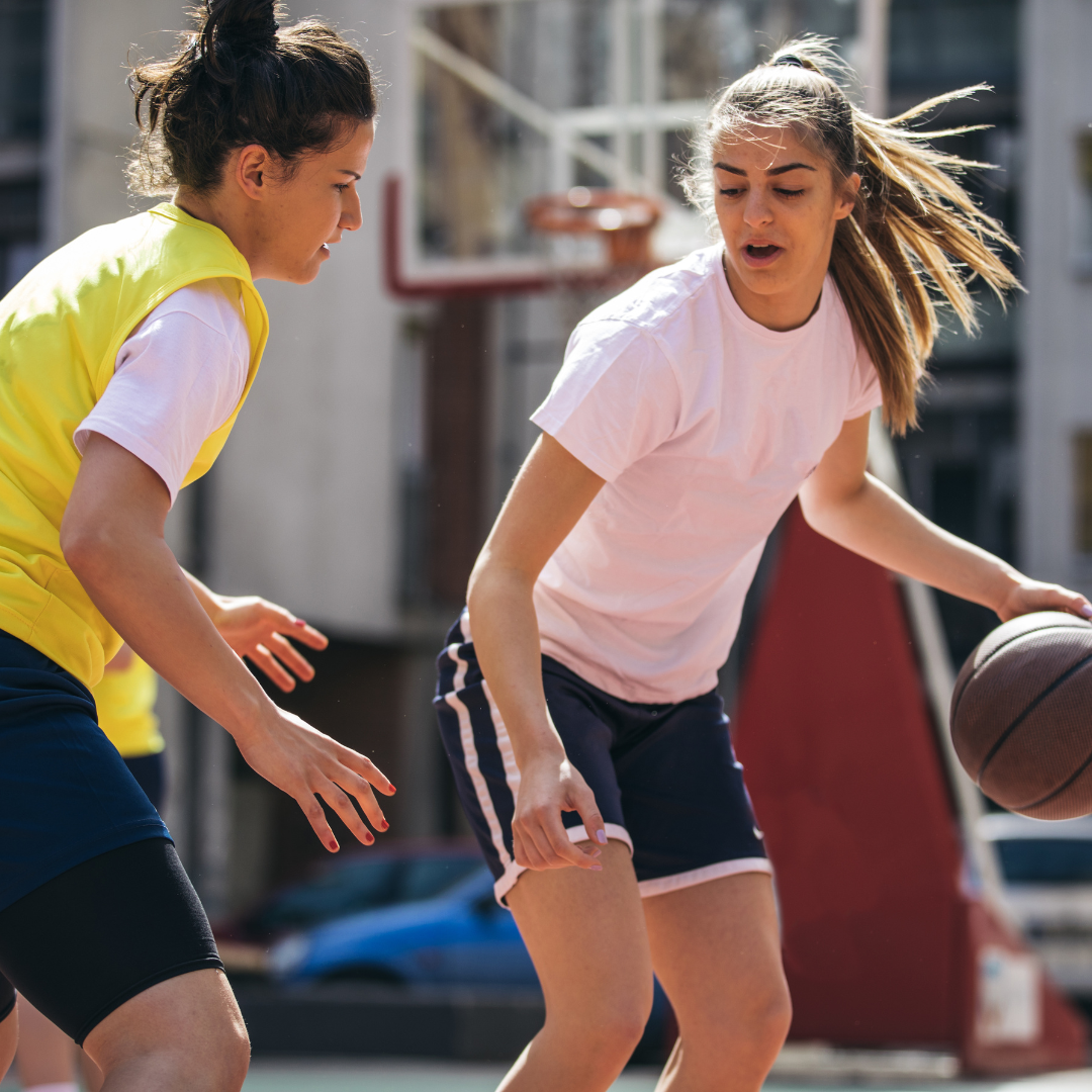 Two girls playing basket ball