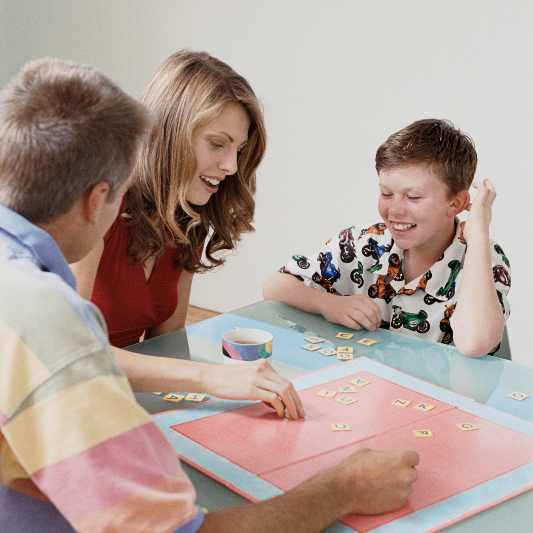 A mother and father playing a board game with their son