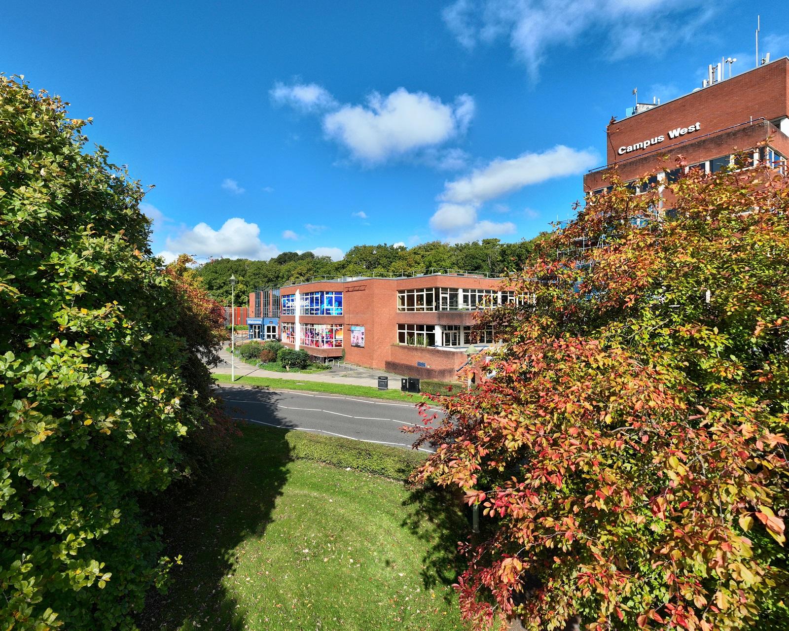 Campus West building with grass and shrubs infront.