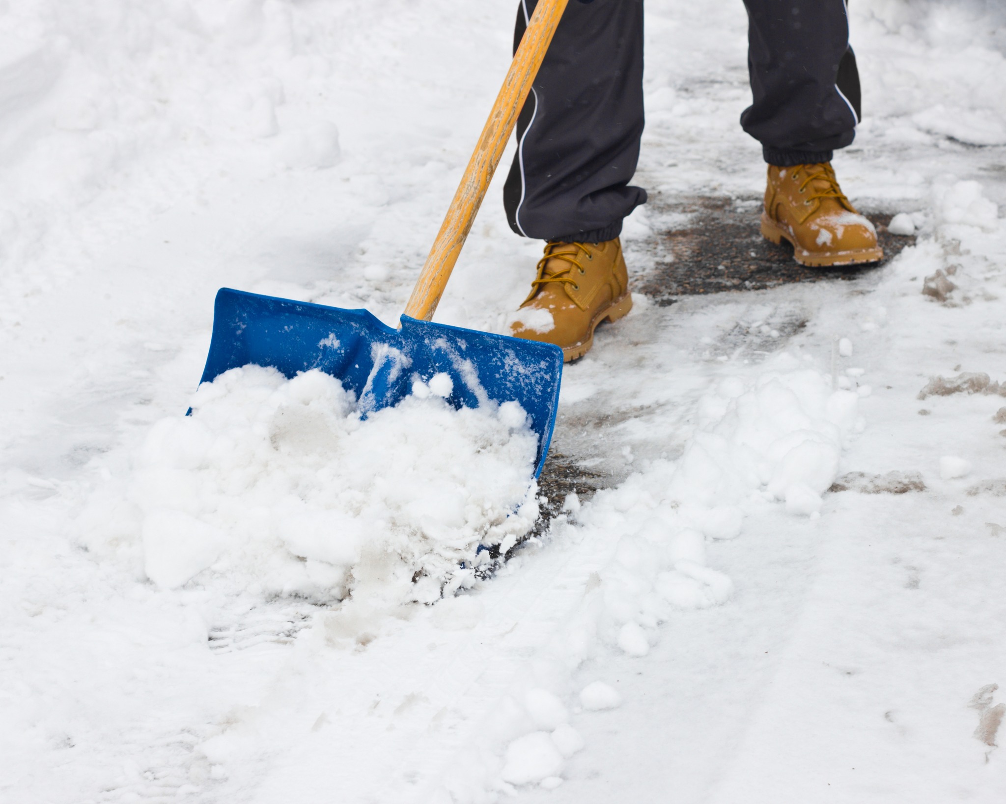 Snow on the ground and somebody clearing it away.